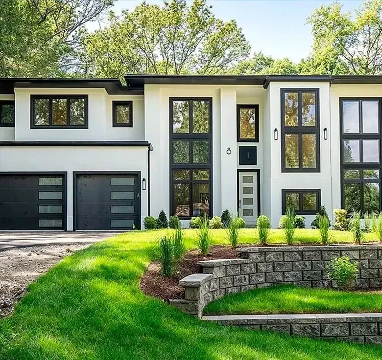 Modern white two-story house with black accents, double garage, and landscaped front yard