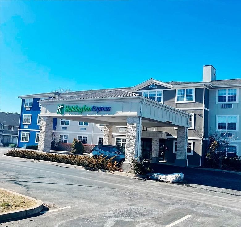Holiday Inn Express hotel entrance with covered driveway, blue sky.