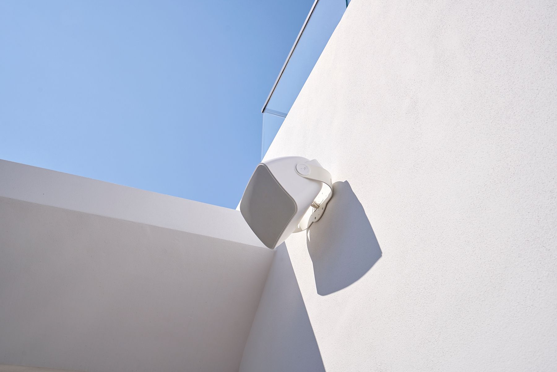 A white wall with a blue sky in the background.