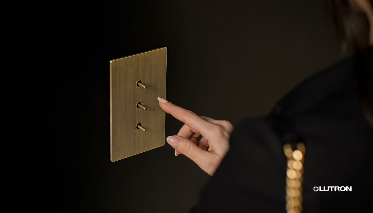 A woman is pressing a light switch with her finger.
