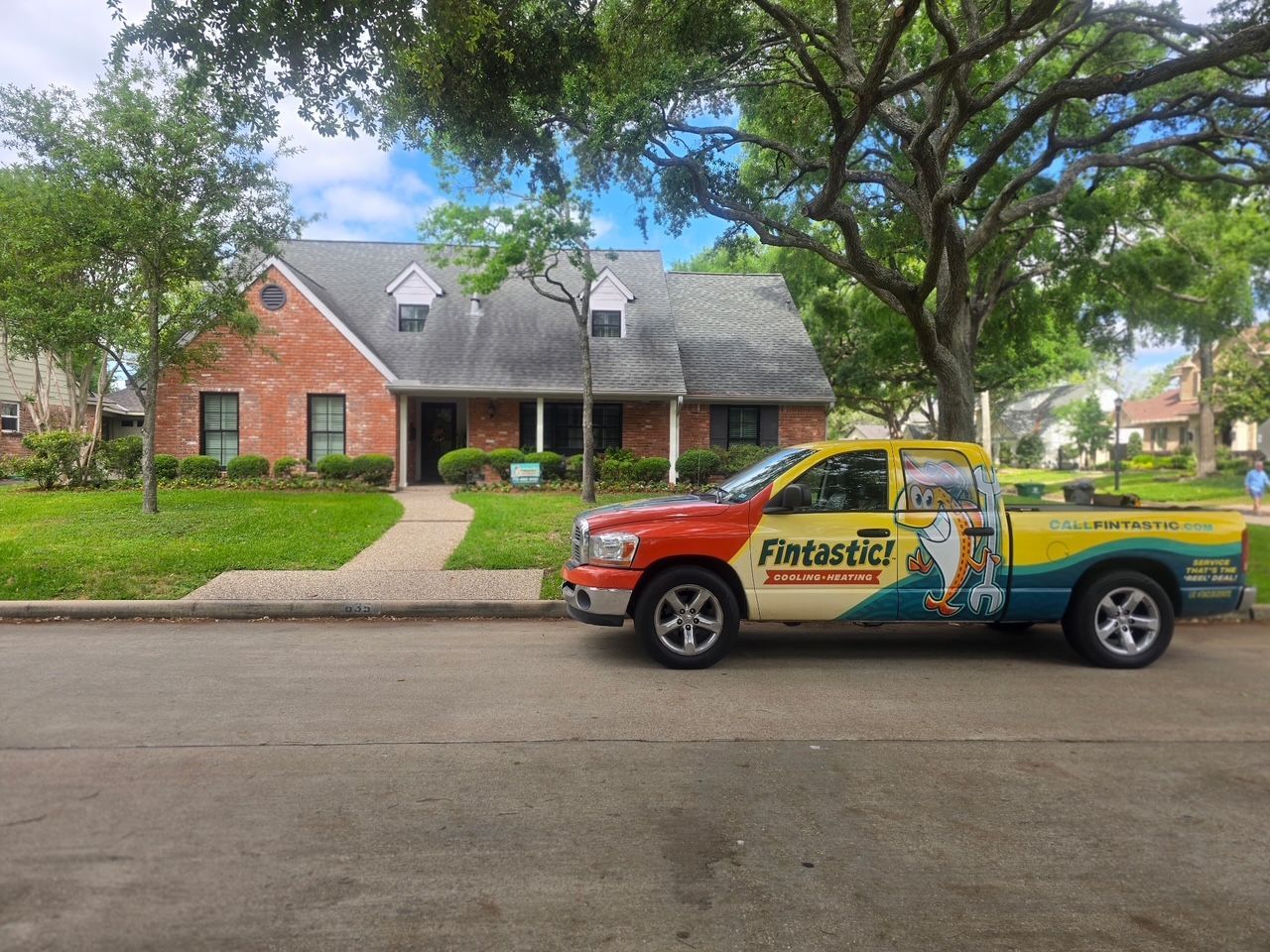 Pickup truck with Fintastic logo on the side parked outside a residential home