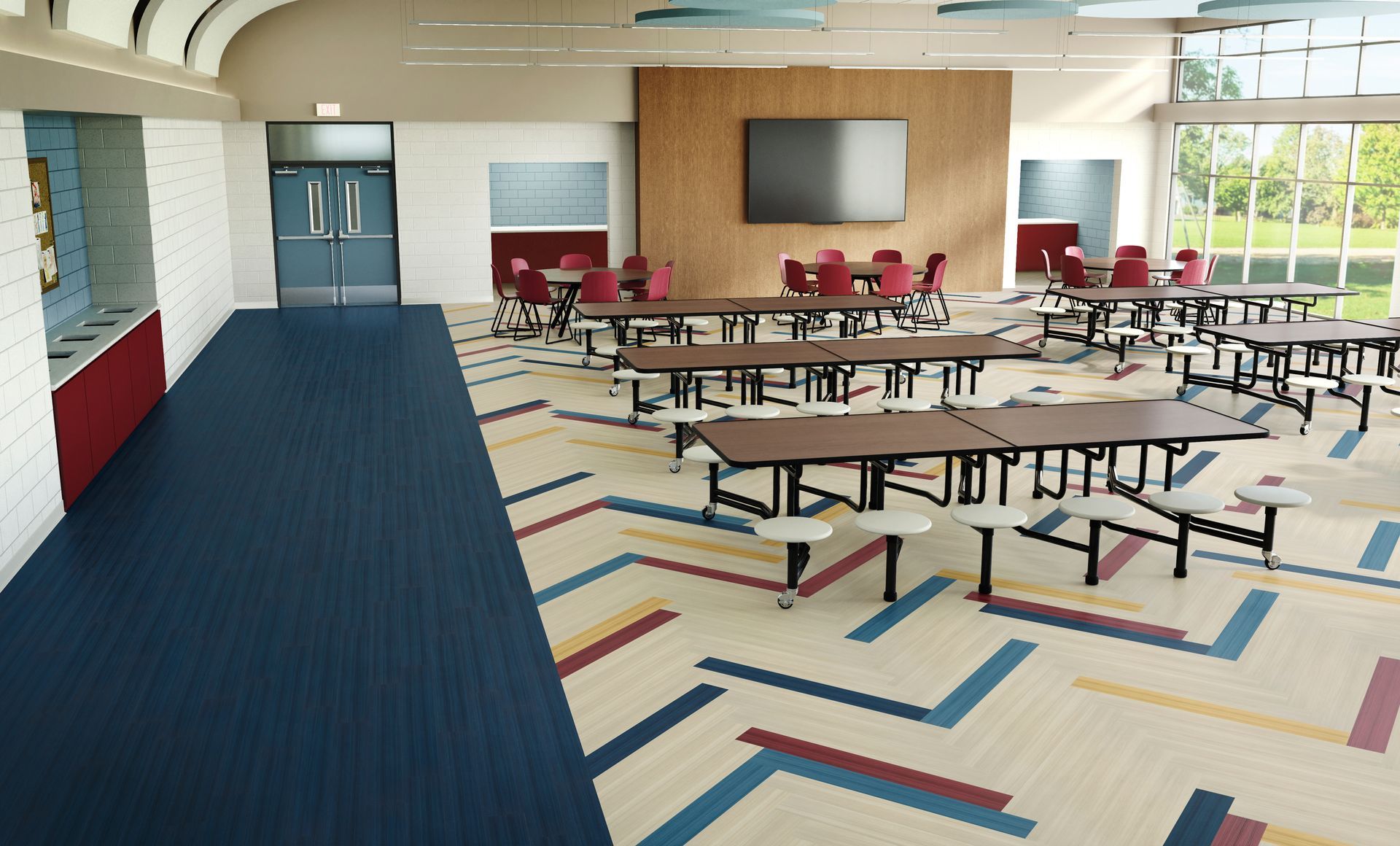 Empty school cafeteria with long tables, red chairs, blue carpet, and large windows along the wall