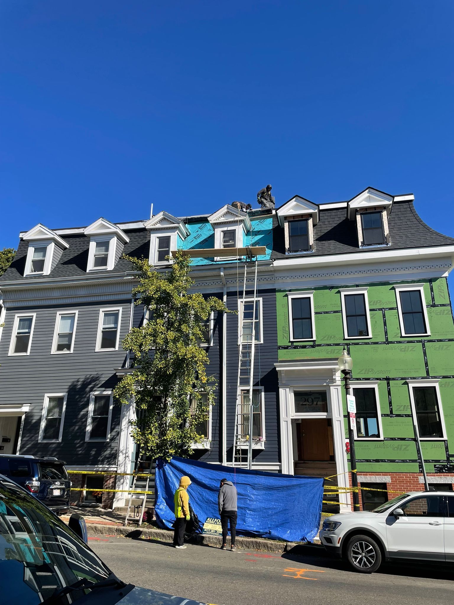 Exterior of a house with gray siding, white window frames, and two windows.