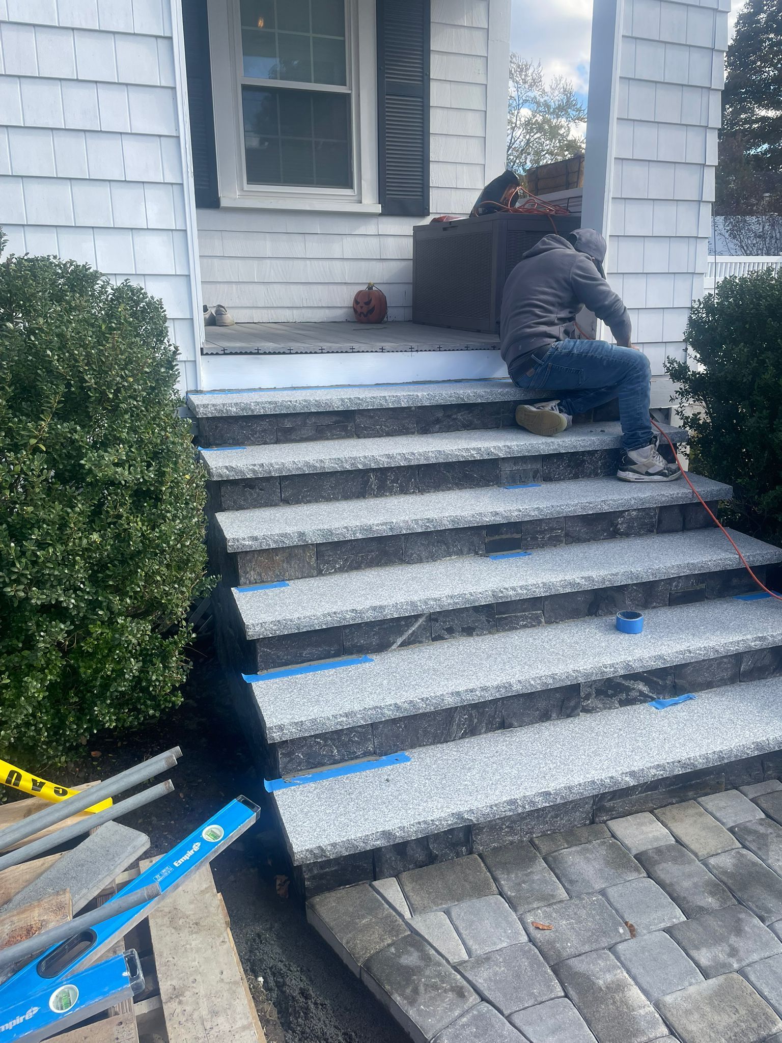 Concrete steps leading up a grassy hill with a blue railing.