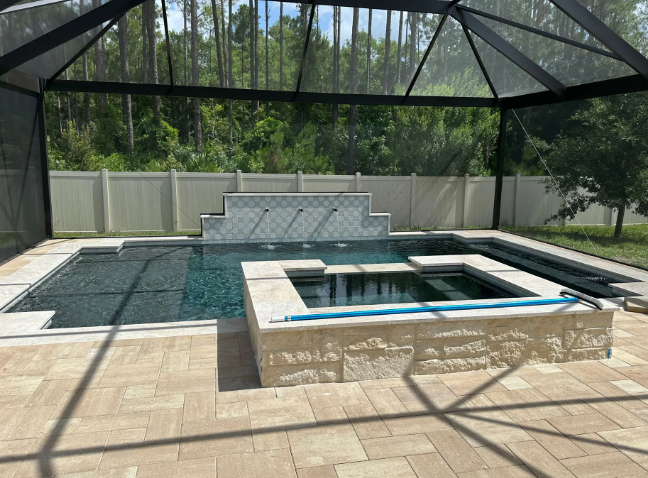 Pool area with pool, spa, water feature, and screened enclosure.