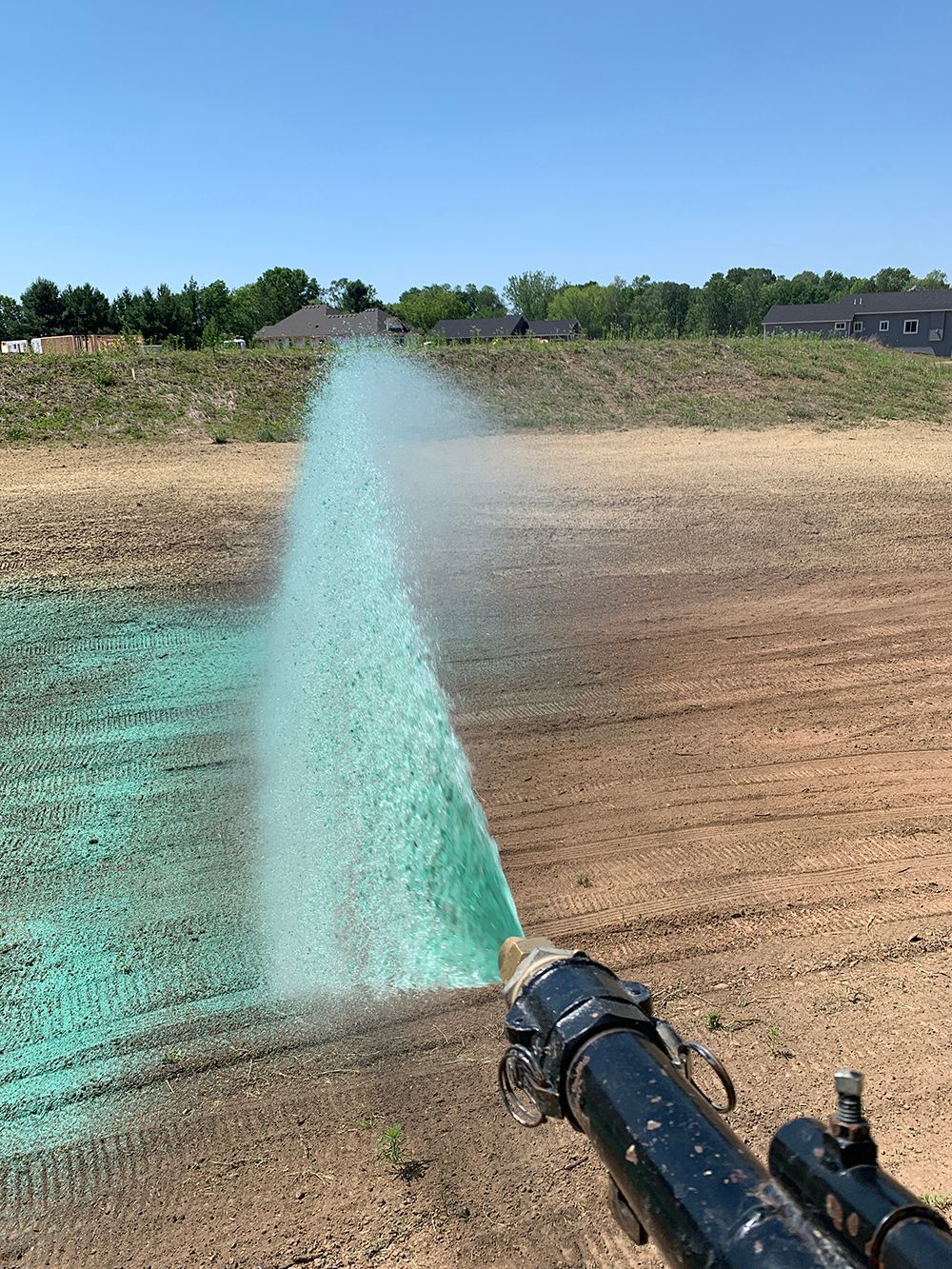 A person is spraying green on a field