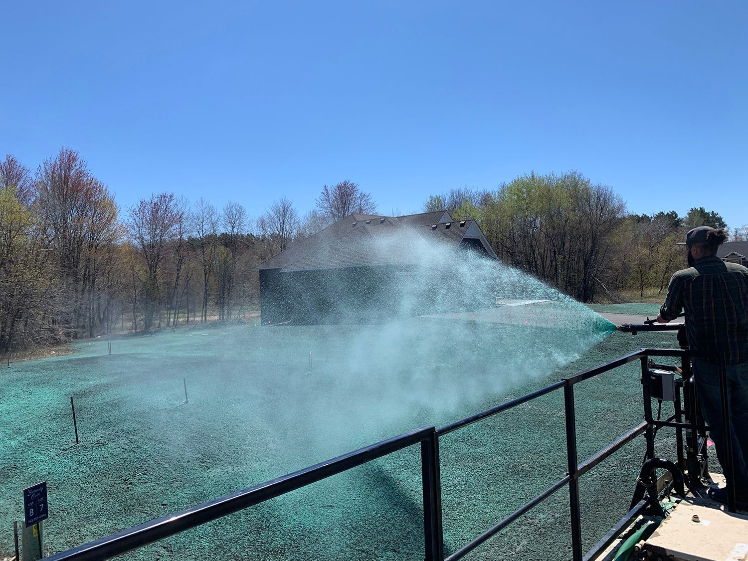 A man is spraying on a lush green field