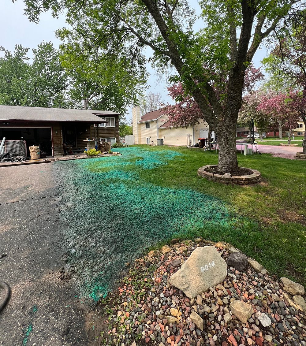 A house with a lot of grass and rocks in front of it