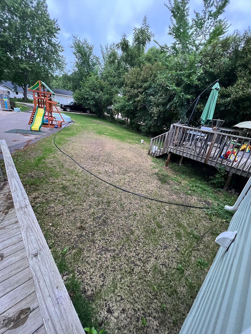 A backyard with a playground and a deck