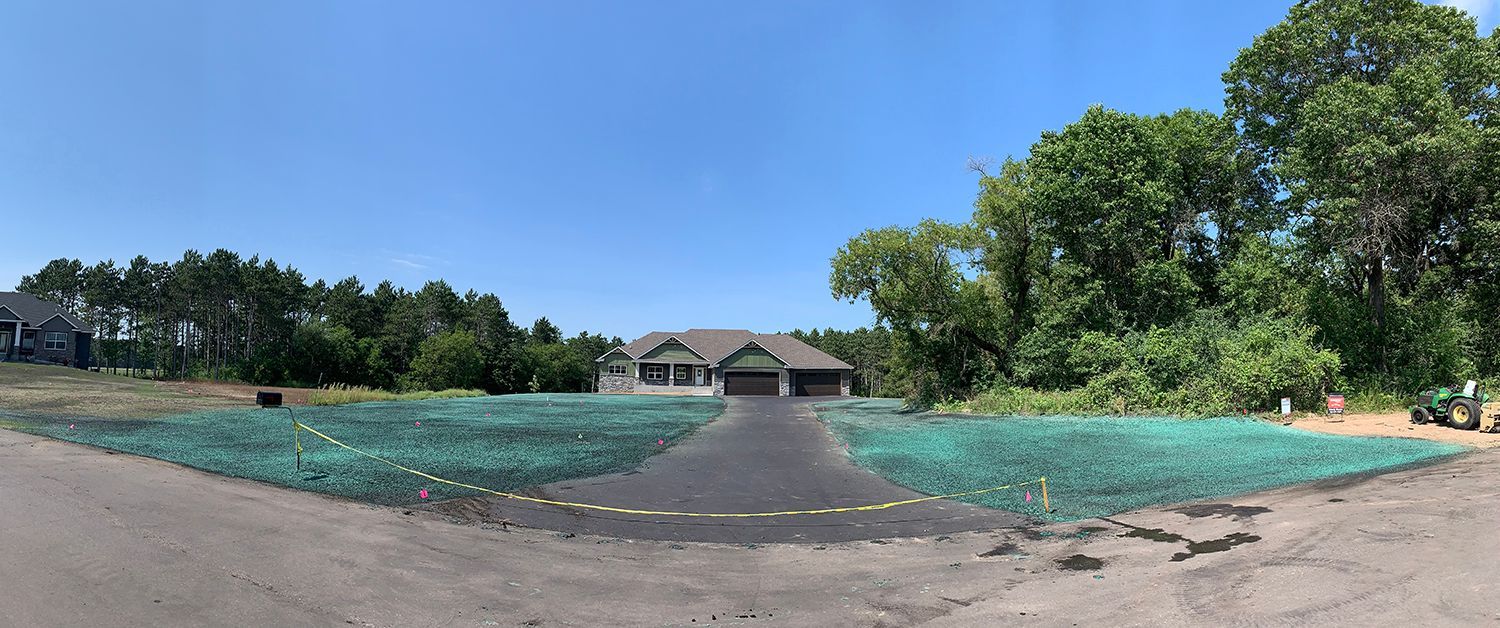 A large house is sitting on top of a lush green field