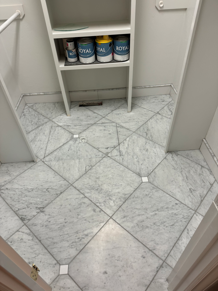 White marble tile floor with shelves and paint cans.