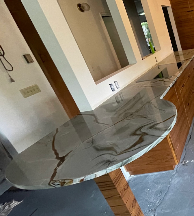 Epoxy countertop with brown veining; near a window and wooden support.