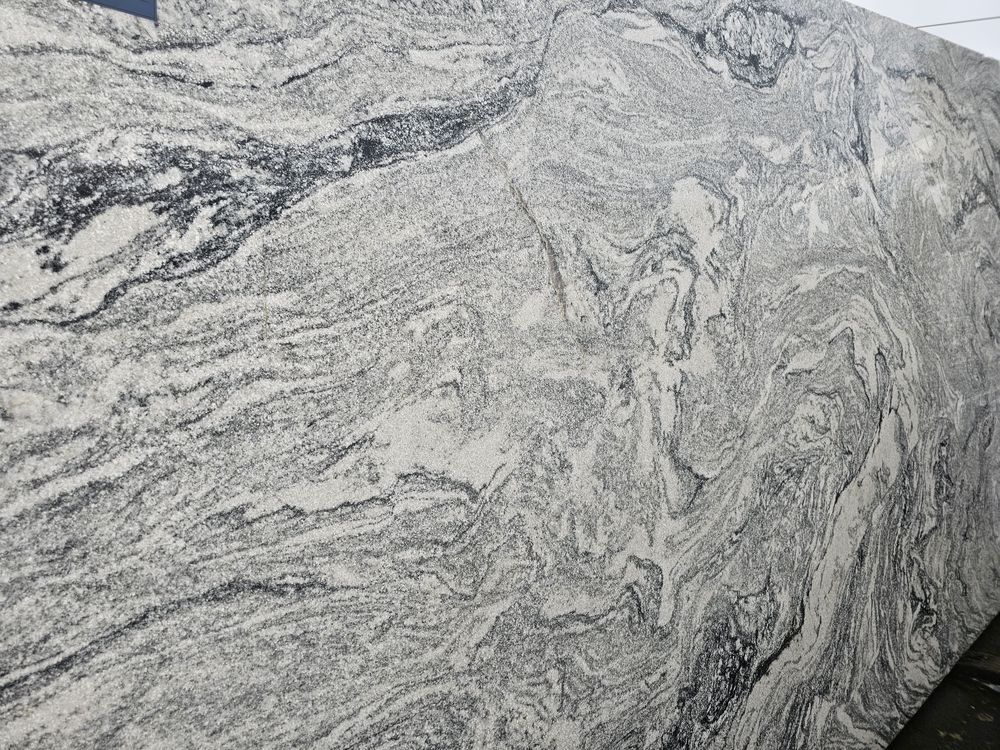Gray and white marbled stone surface with swirling veining and textured patterns