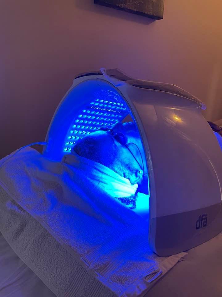 A person is laying under a blue light.