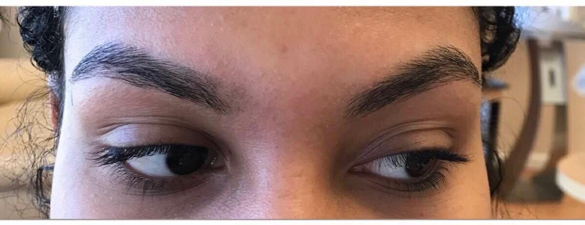 A close up of a woman 's face with black eyebrows.