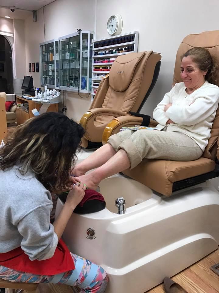 A woman is getting her feet painted at a nail salon.