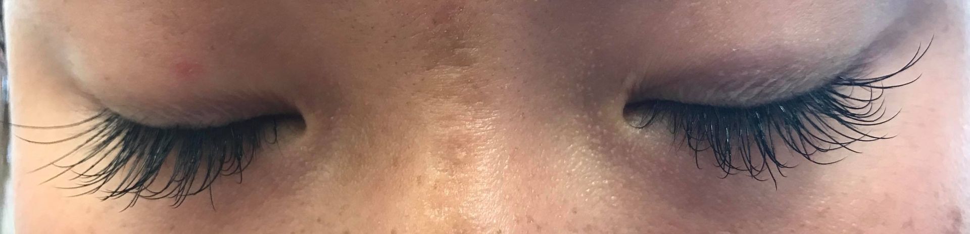 A close up of a woman 's eyes with long eyelashes.