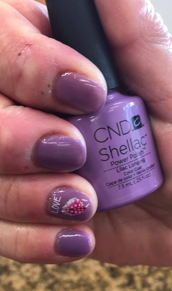 A person is holding a bottle of cnd shellac nail polish.