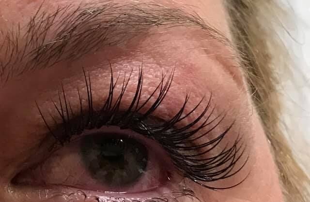 A close up of a woman 's eye with long eyelashes.