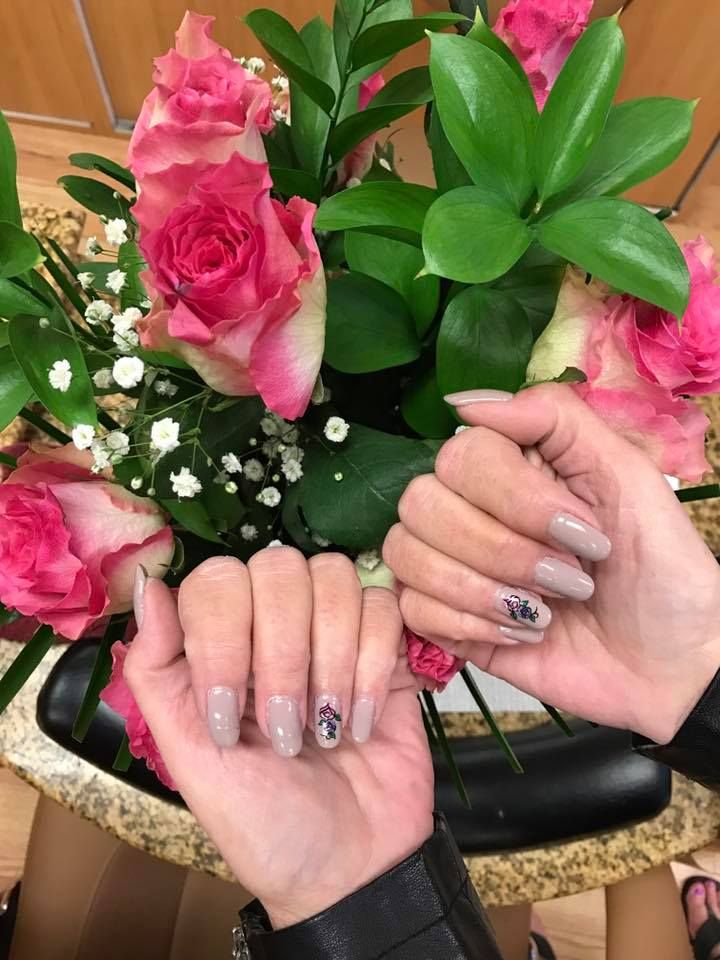 A woman is holding a bouquet of pink roses in her hands.