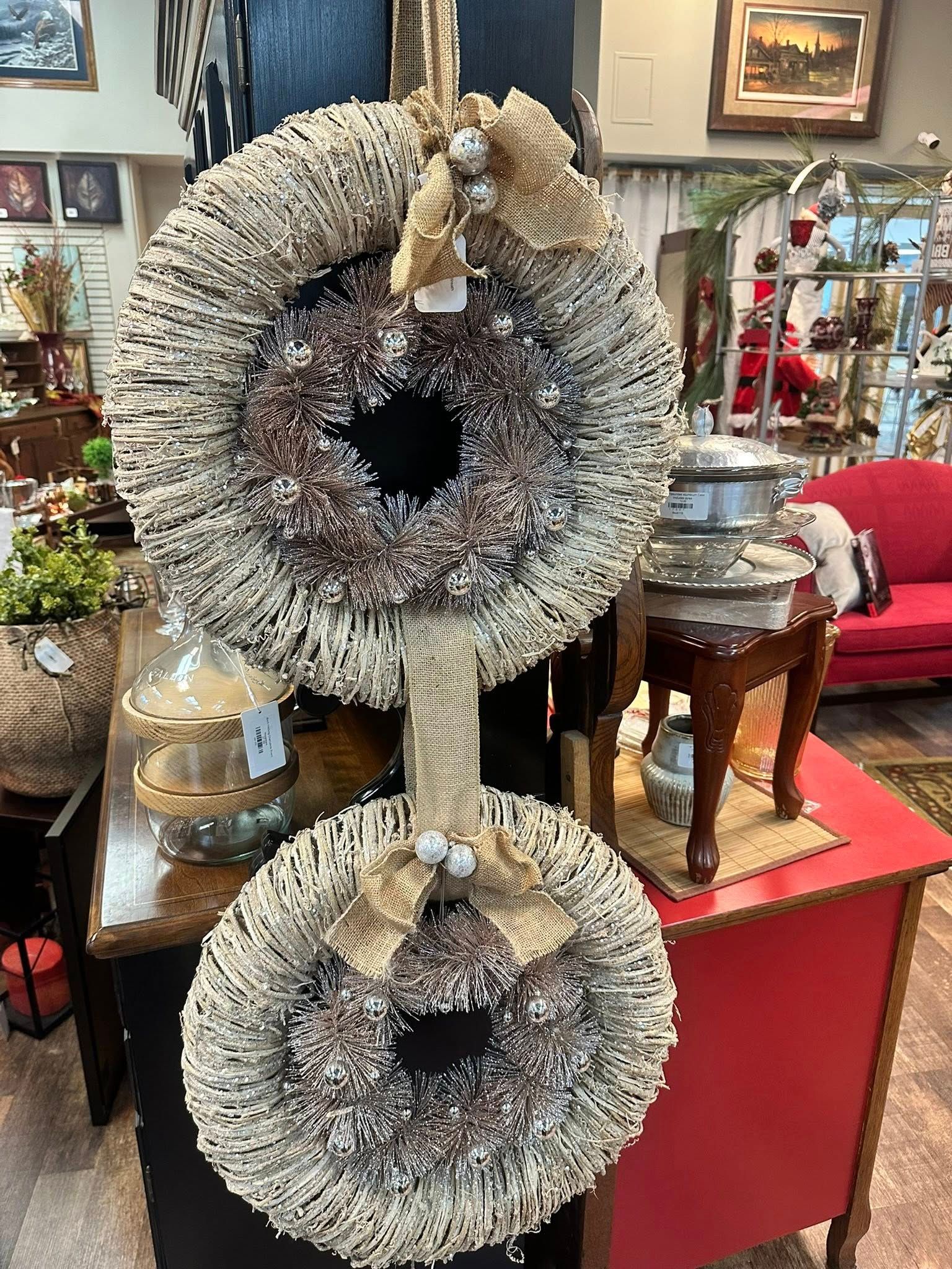 Two wreaths with white and brown decorations hanging in a store.