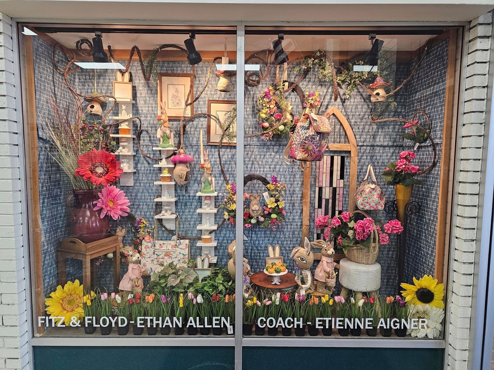 Storefront window display with Easter decorations and floral arrangements.