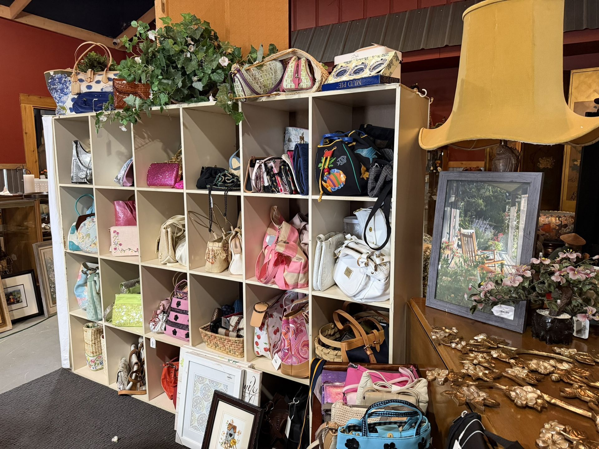 Shelves of assorted gift bags and decor beside a large yellow lampshade in a shop