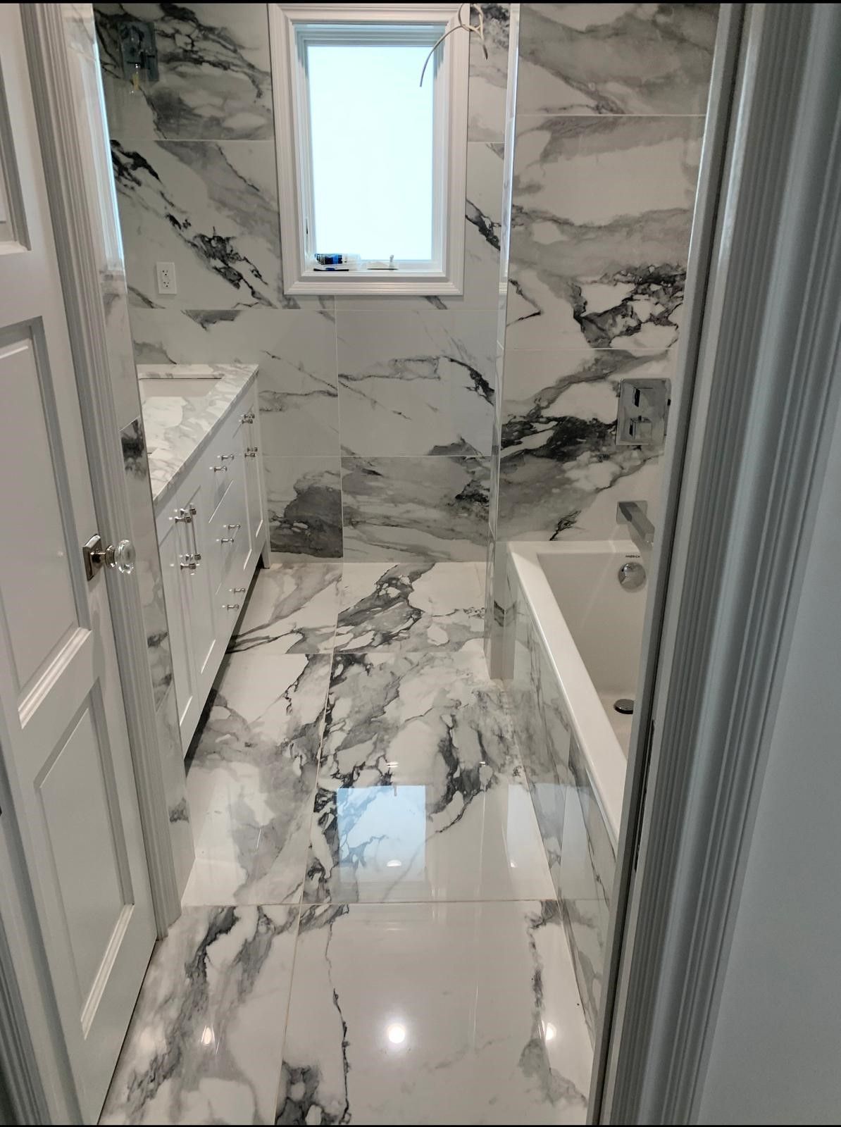a bathroom with a marble floor and a bathtub