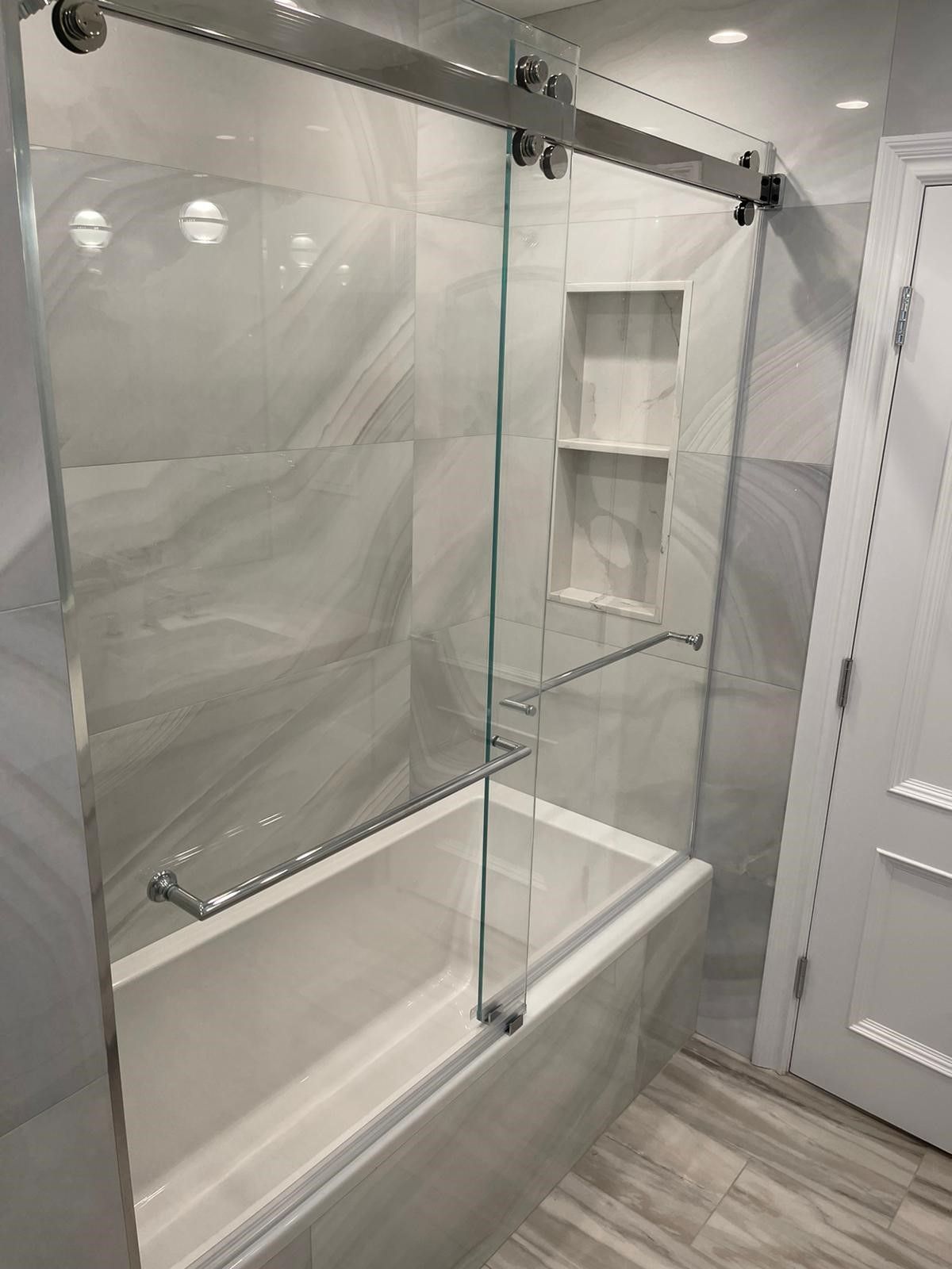 a bathroom with a bathtub and a with a glass door