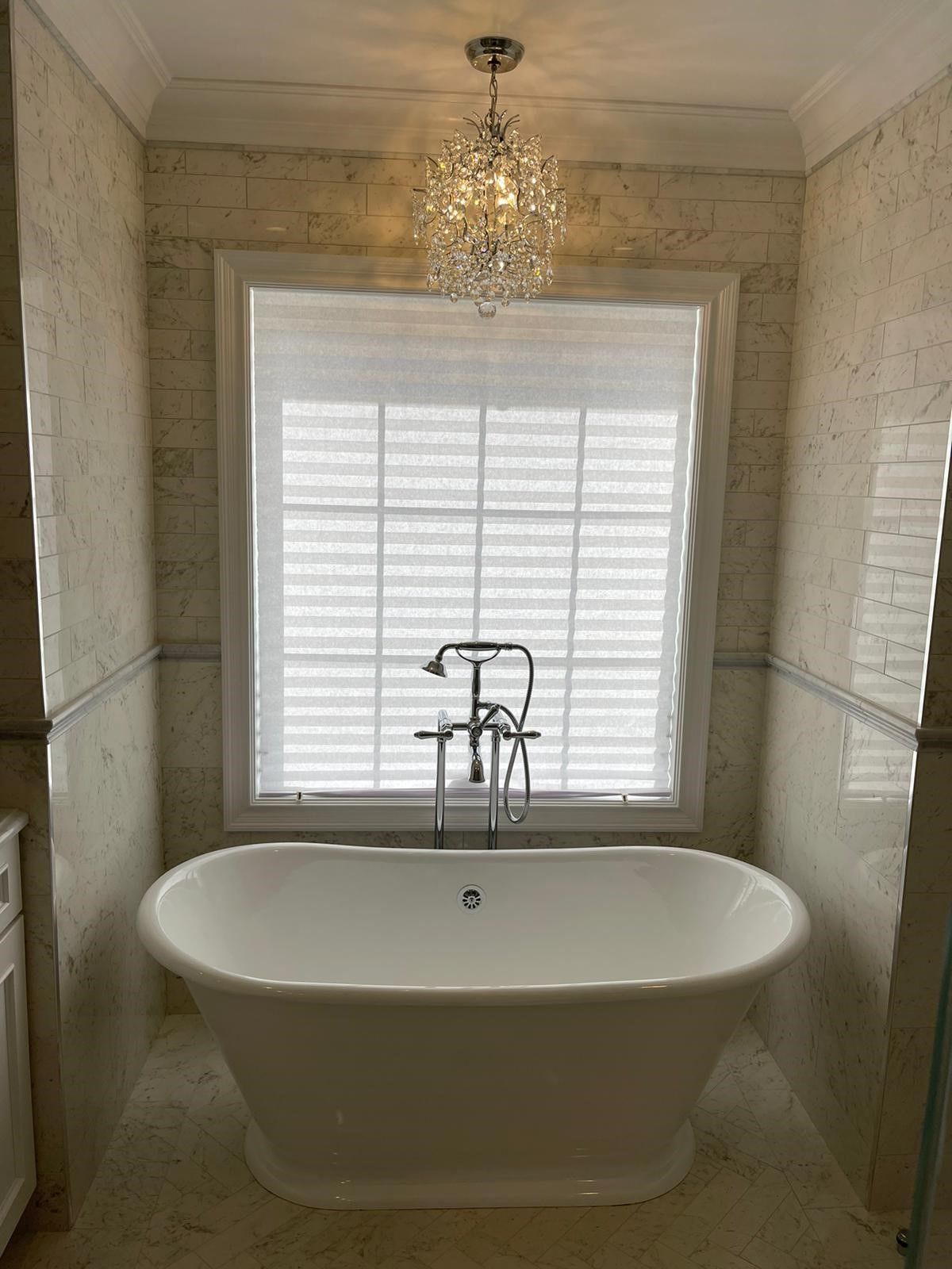 a bathroom with a bathtub and a window with shutters