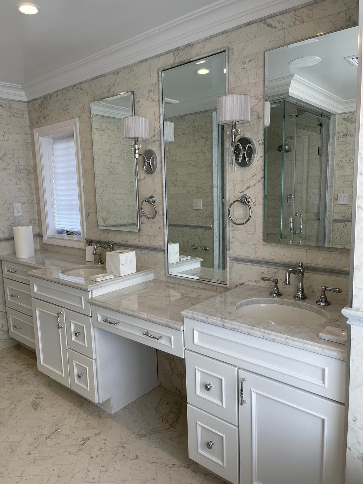 a bathroom with two sinks and three mirrors