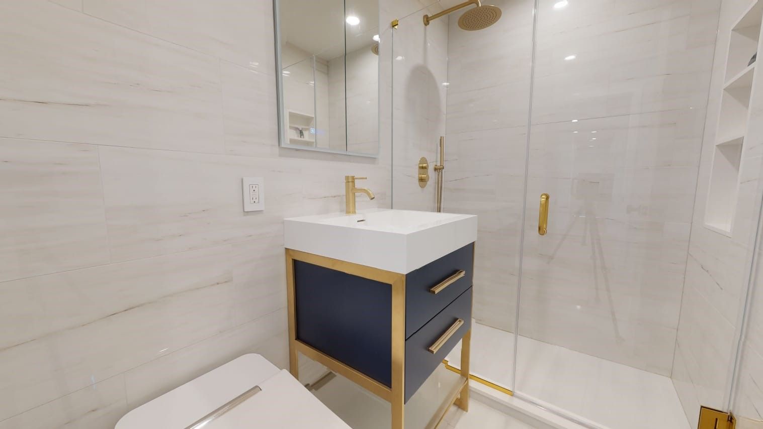 a bathroom with a sink, toilet bowl, shower, and mirror