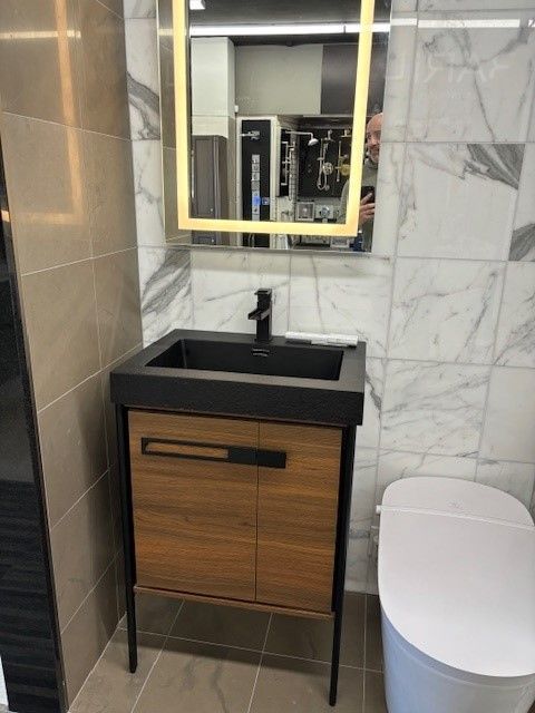 A bathroom with a sink a toilet and a mirror