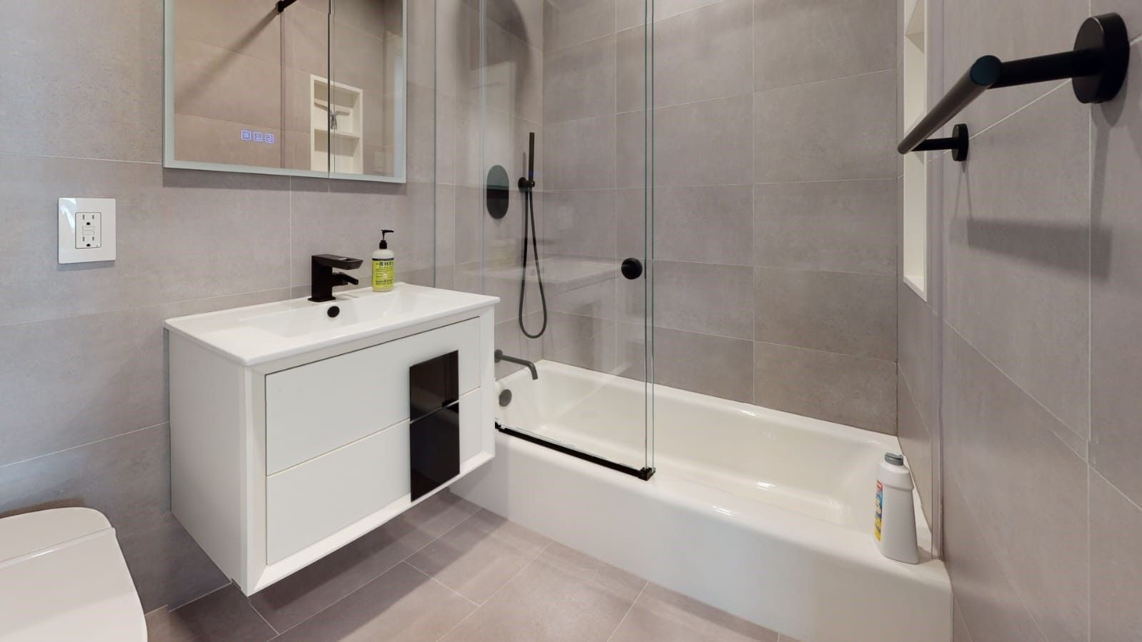 a bathroom with a sink, tub, shower, and mirror