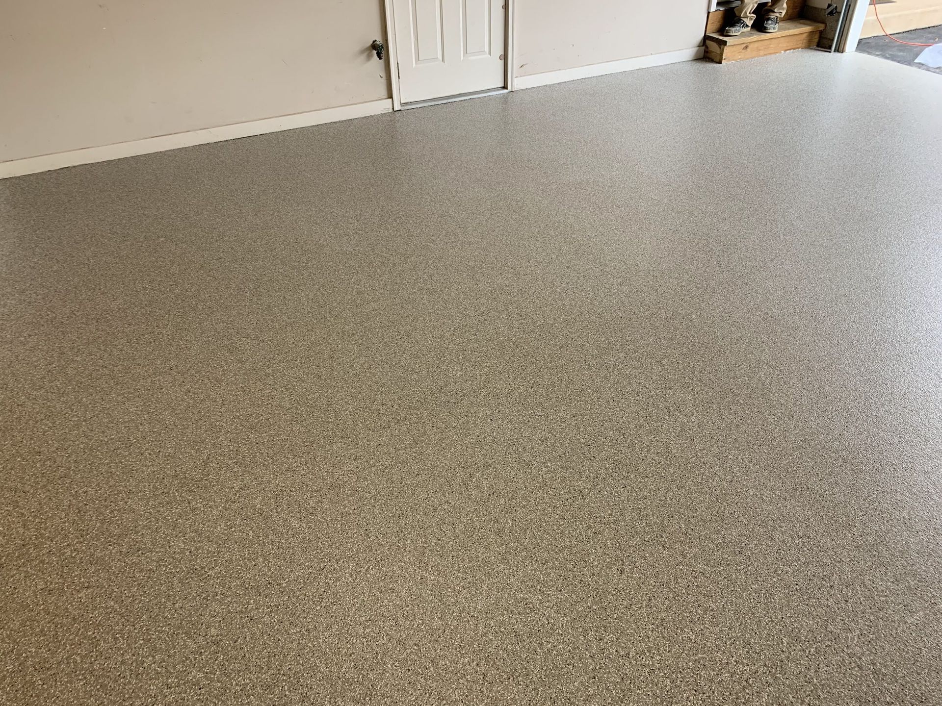 Speckled gray countertop or tabletop in a room with a white wall and doorway in the background