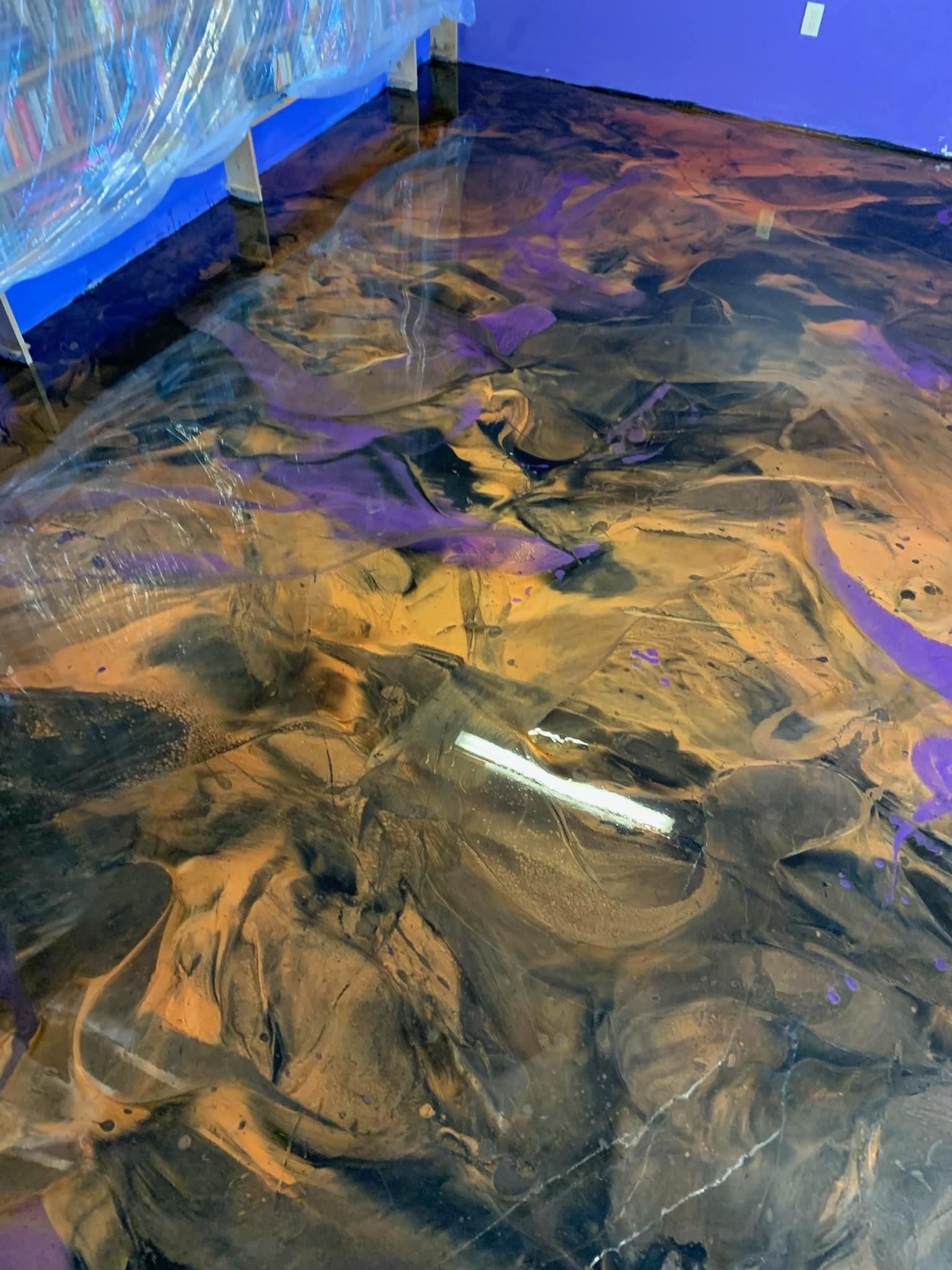 Blue and tan swirled marbled floor or resin surface with a glossy reflection