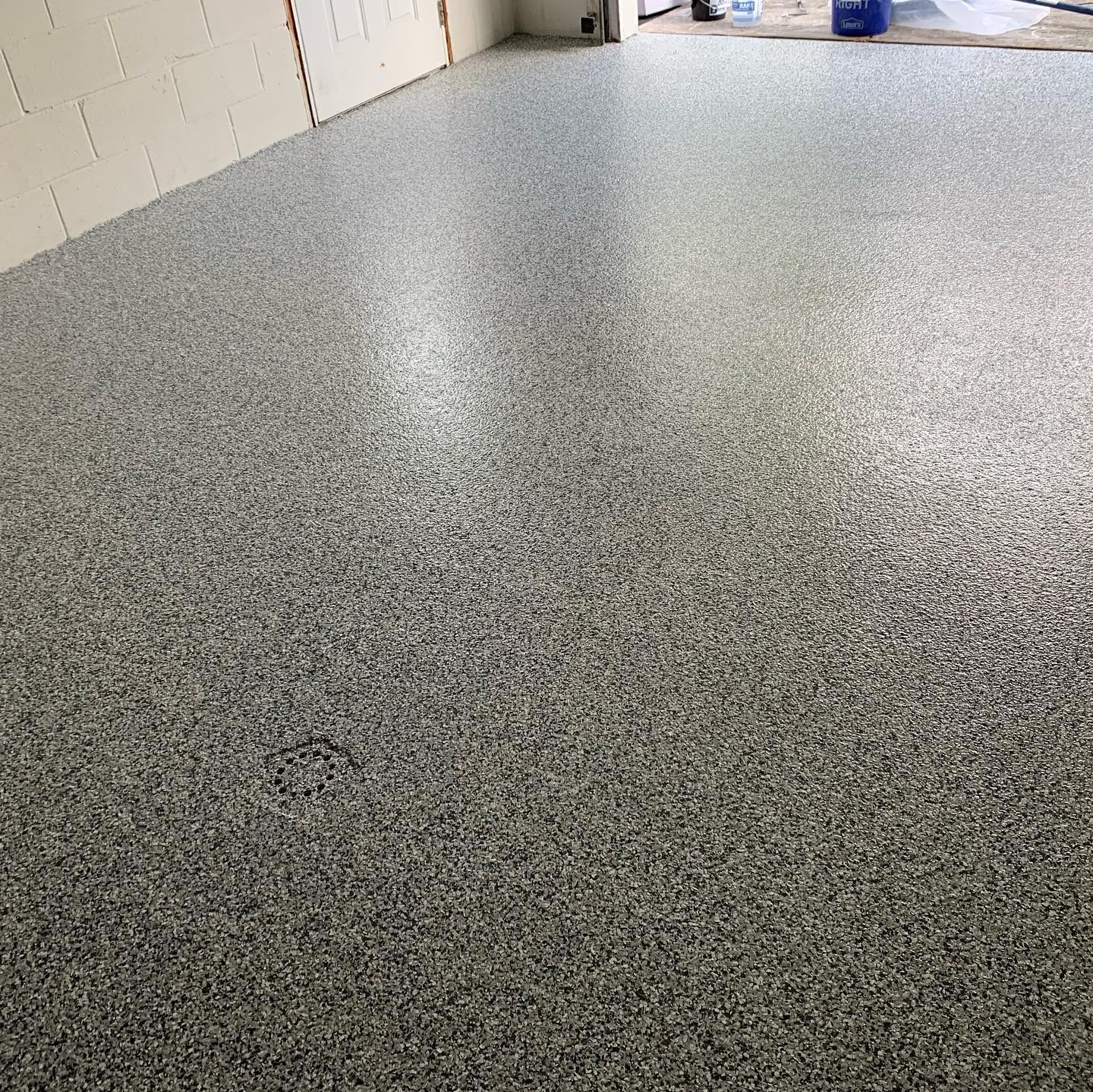 Speckled gray epoxy floor in an indoor room with white walls