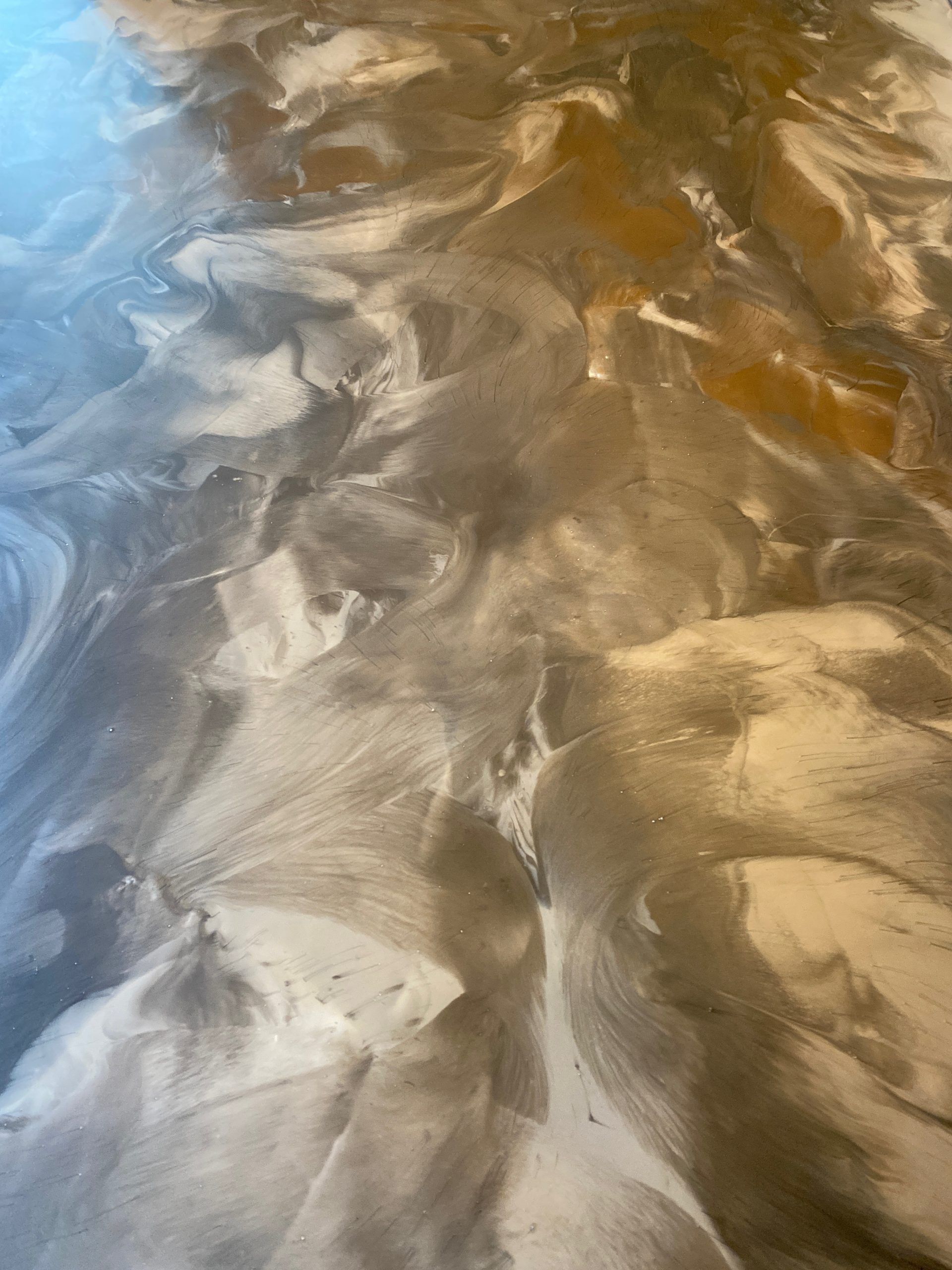 Abstract close-up of rippled sand with blue-gray and golden highlights