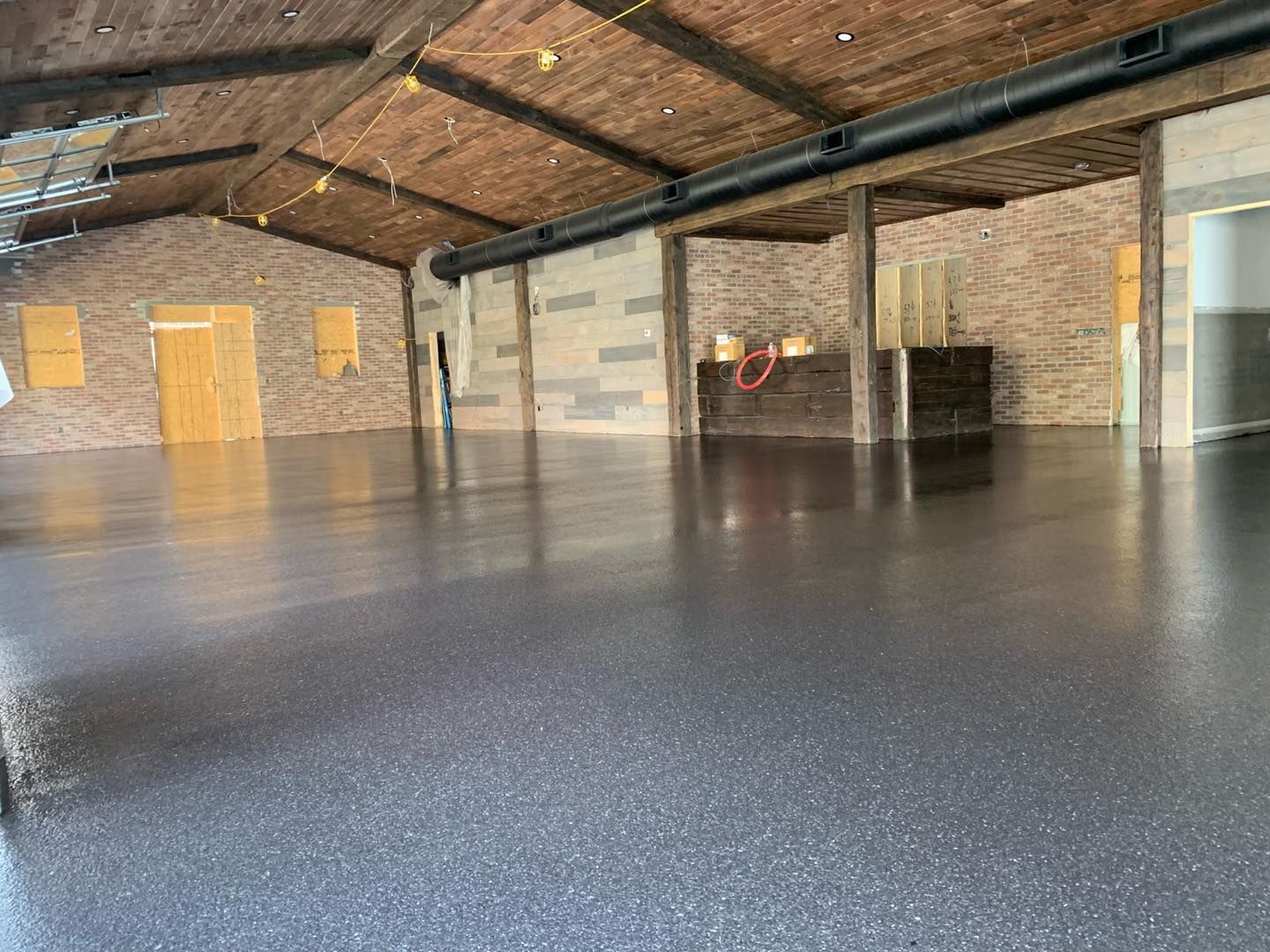 Empty industrial warehouse with a polished concrete floor and exposed brick walls