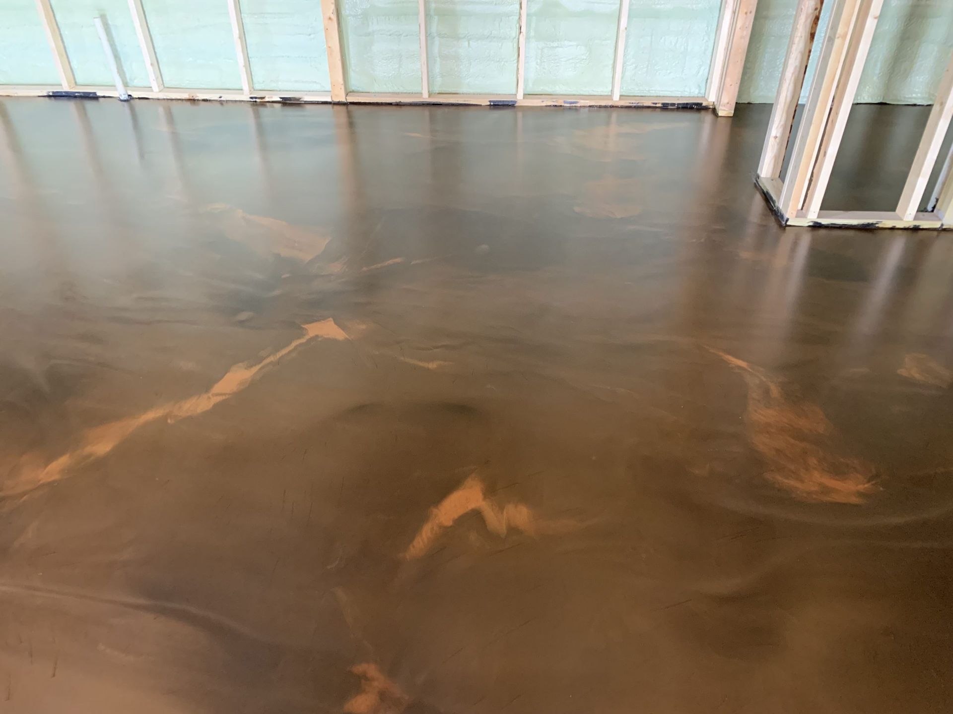 Shiny brown floor with light reflections in an empty room with glass walls