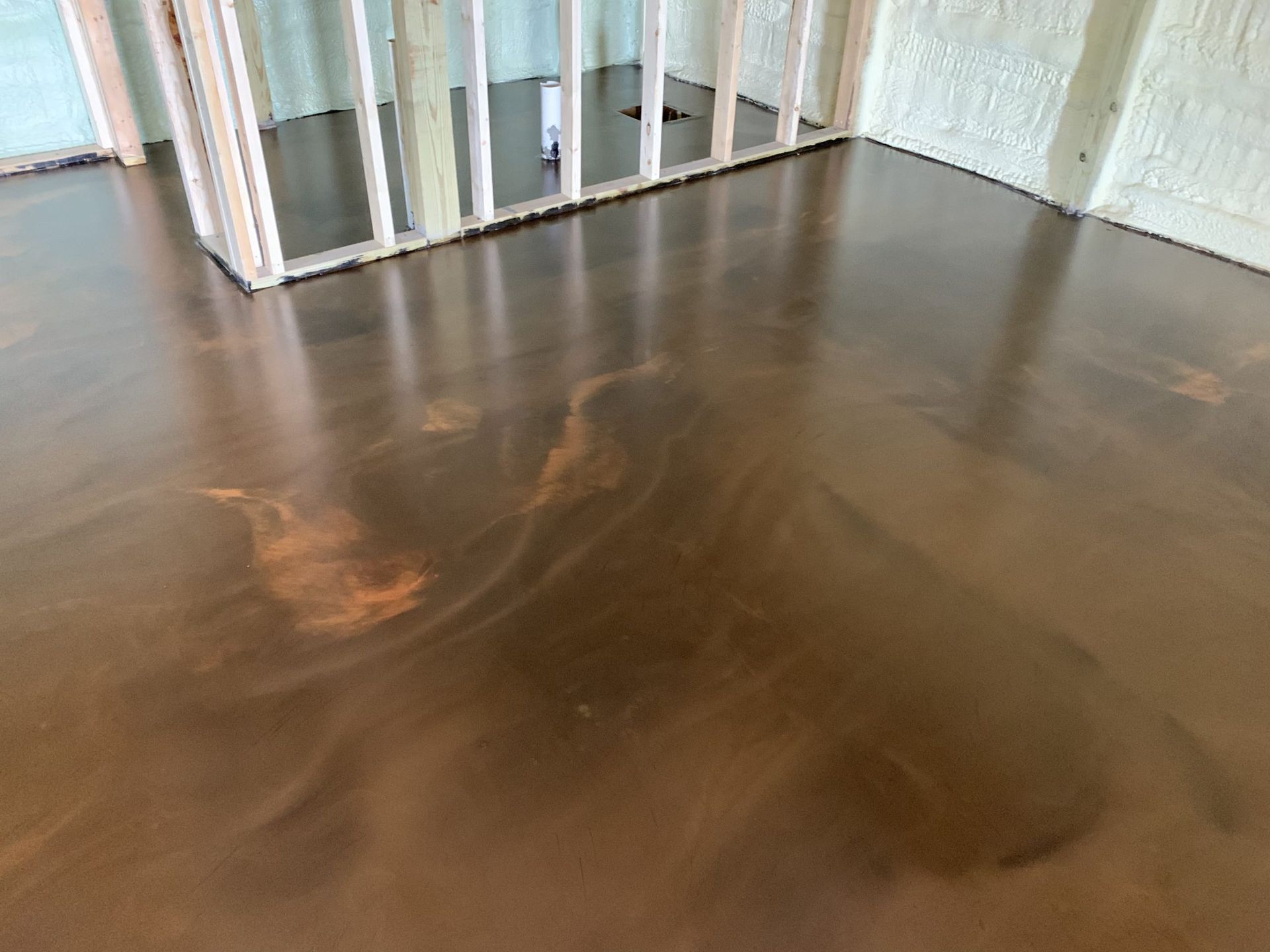 Glossy brown hardwood floor in a room with a white railing and wall trim