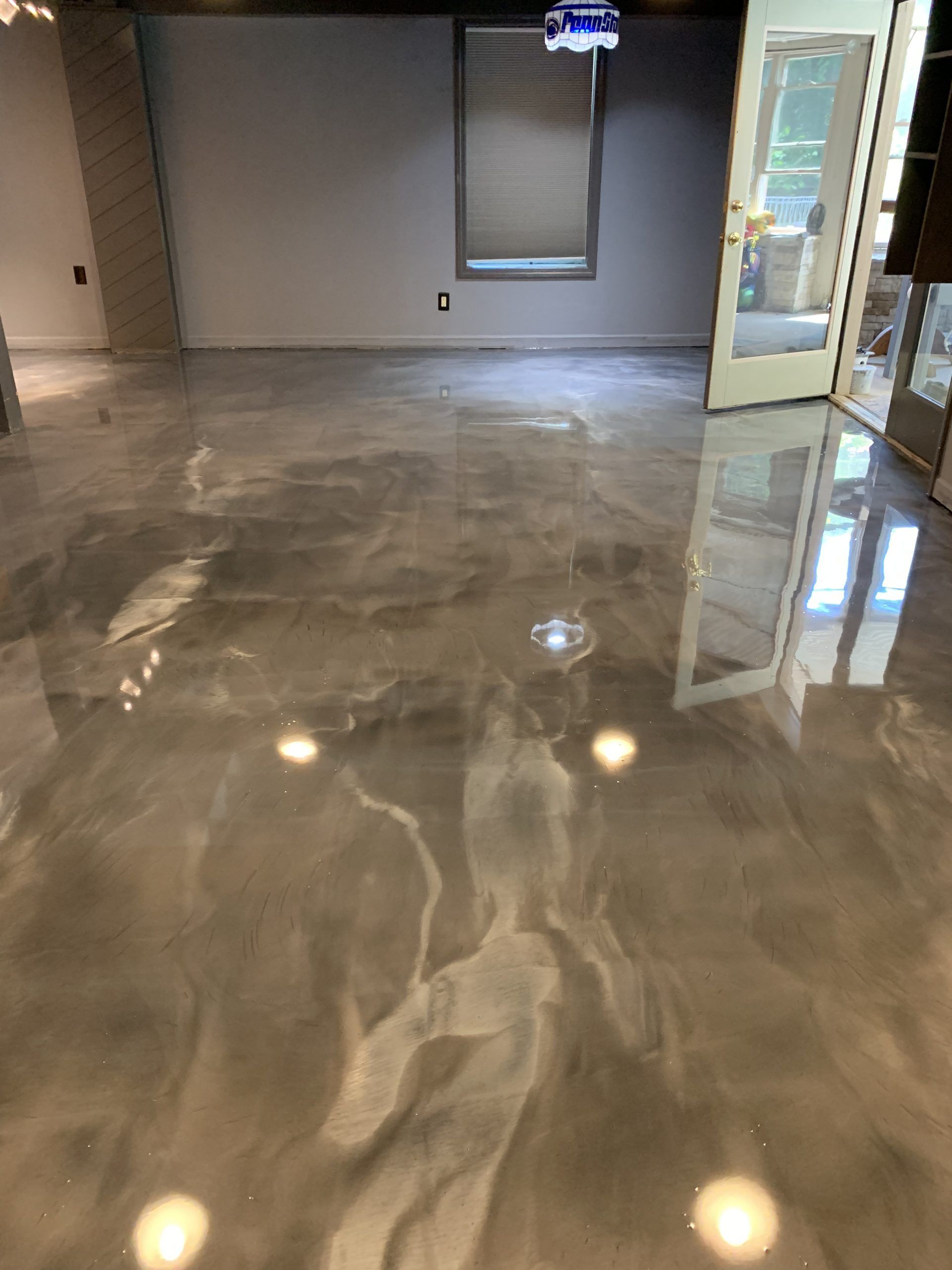 Empty modern room with polished gray marble floor and a glass door on the right.