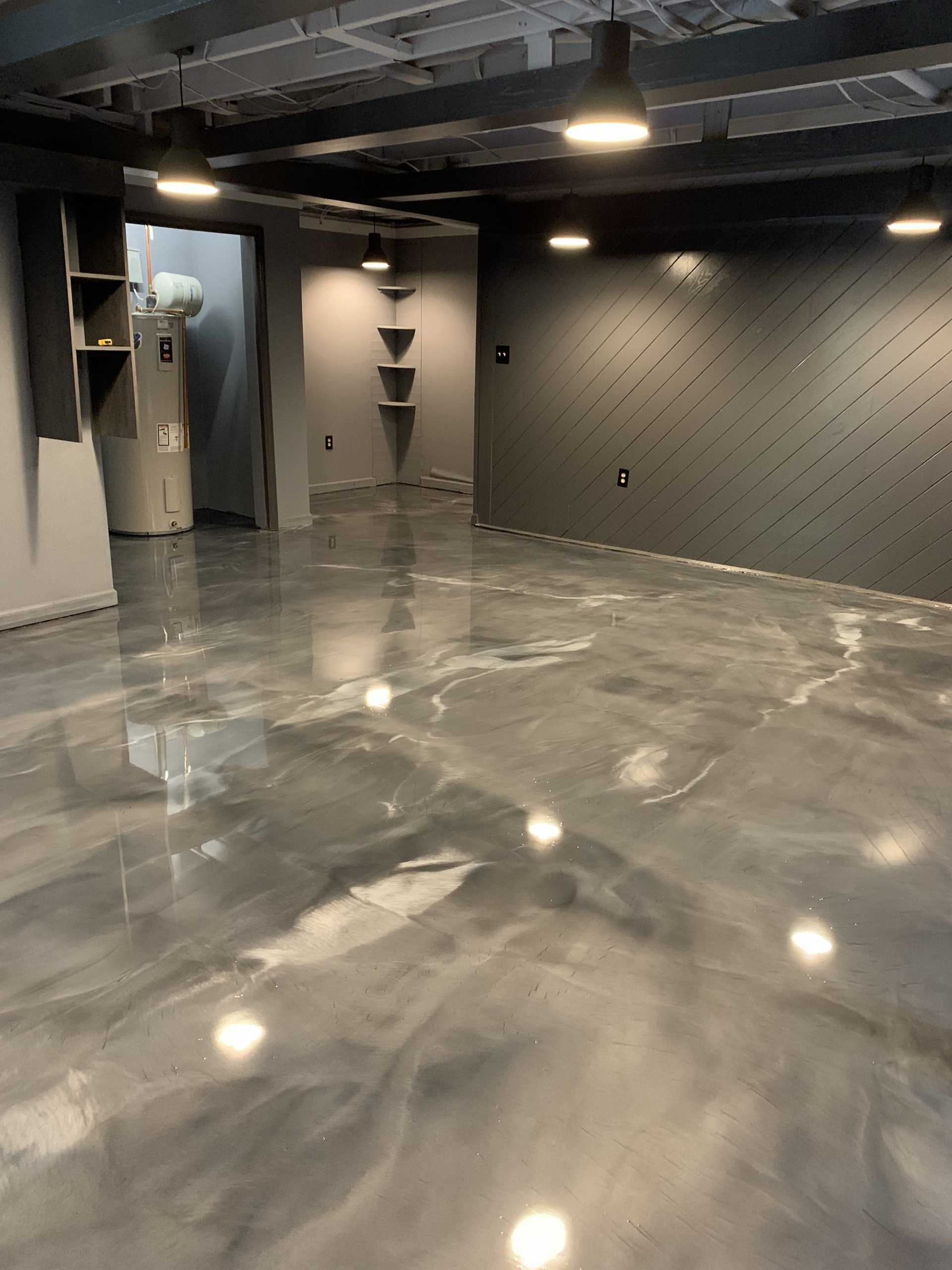 Empty polished gray room with black walls, ceiling lights, and a glossy reflective floor