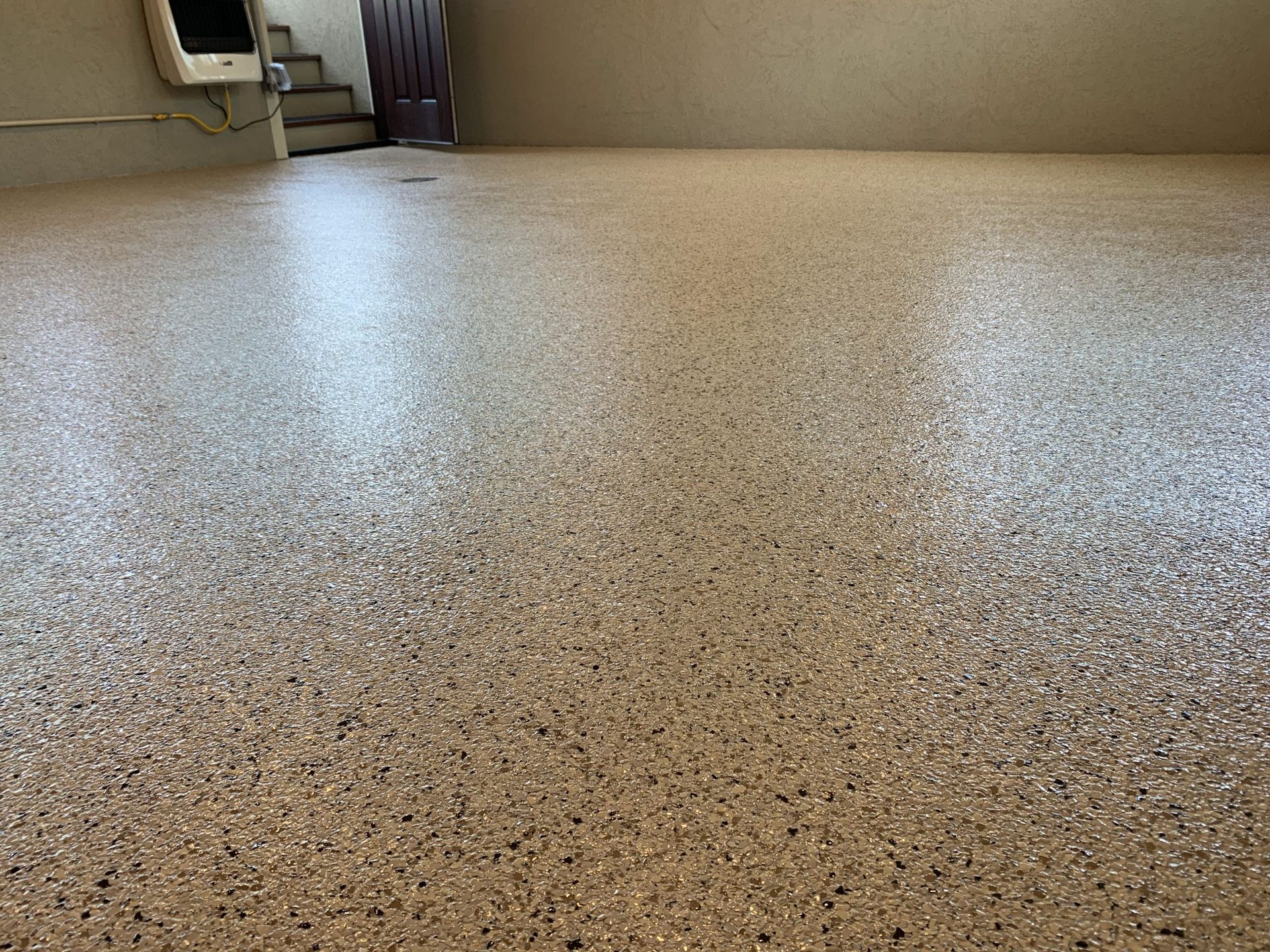 Terrazzo floor in a hallway or room, viewed from low angle with a doorway in the background