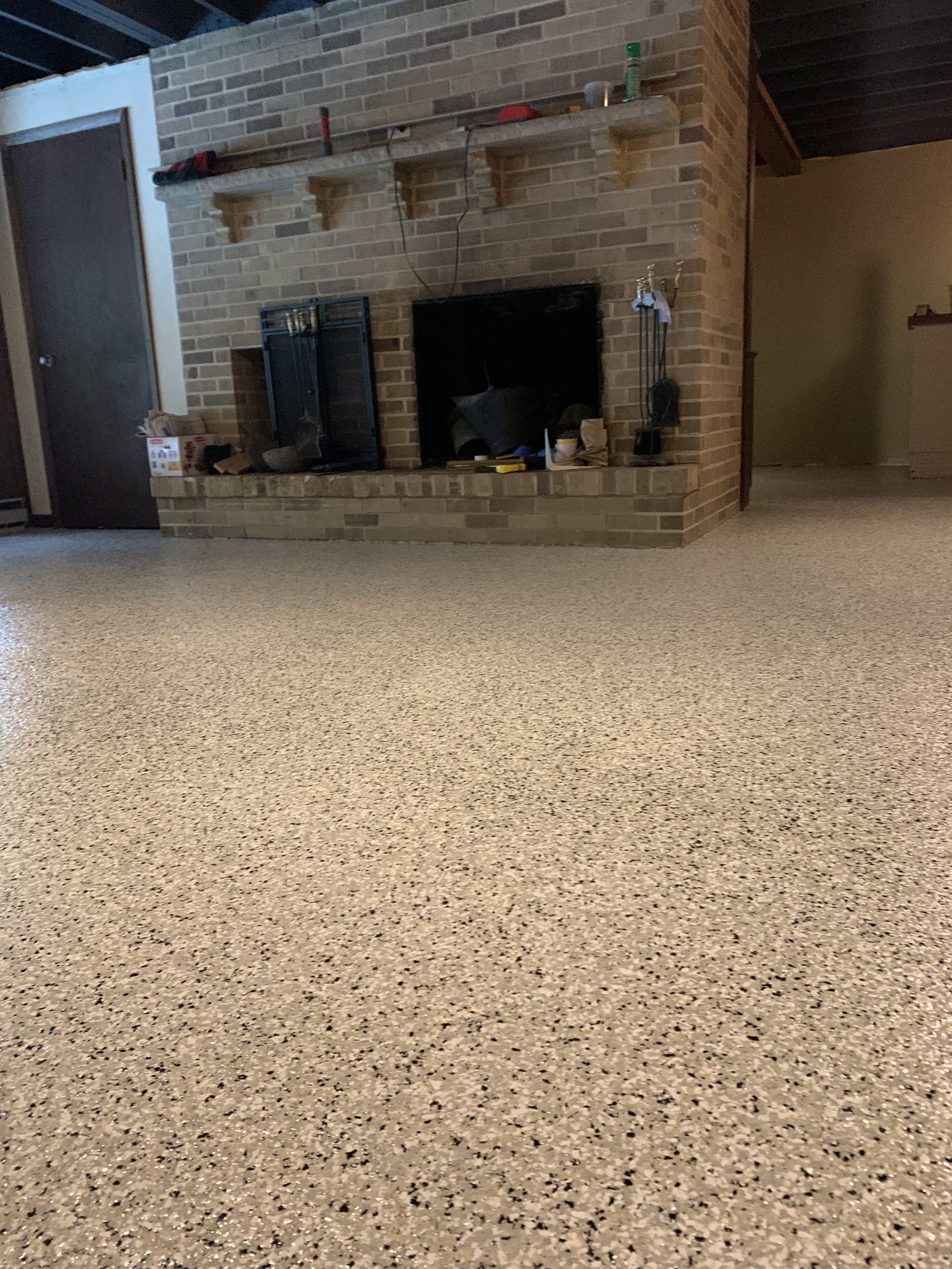 Empty carpeted living room with brick fireplace and beige walls