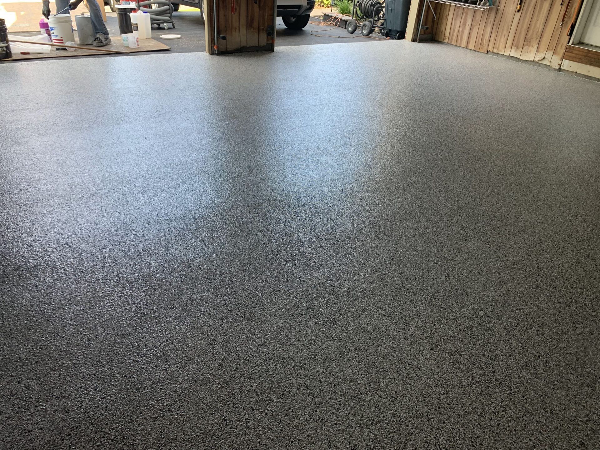 Freshly coated speckled concrete floor in a garage or workshop area