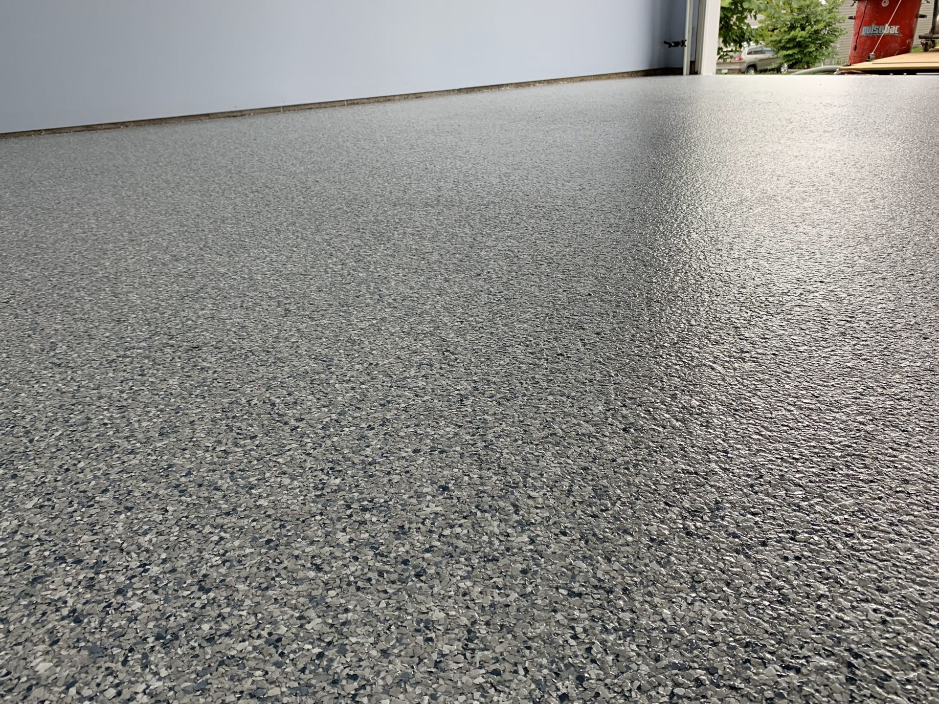 Low-angle view of a speckled gray floor or countertop with a blurred background.