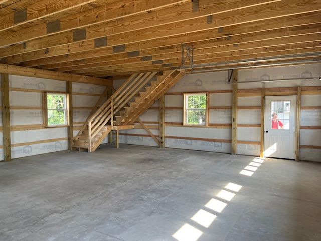 An empty garage with stairs leading up to the second floor