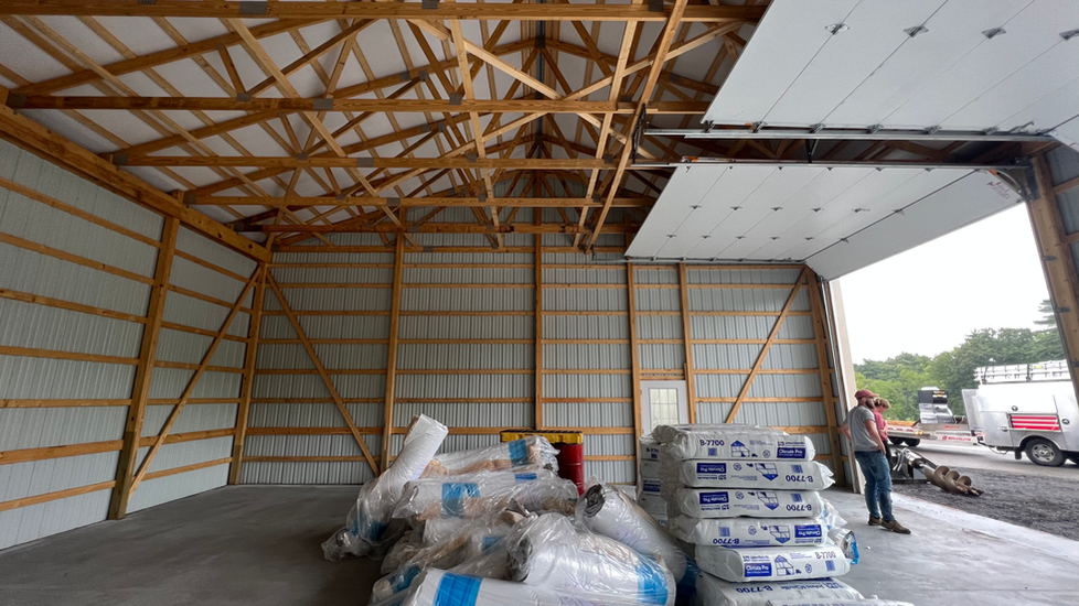 A man is standing in a building with a lot of bags of insulation.