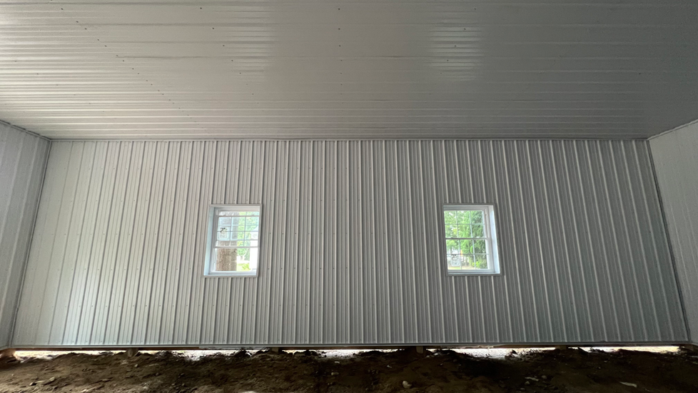 There are two windows in the wall of a building.